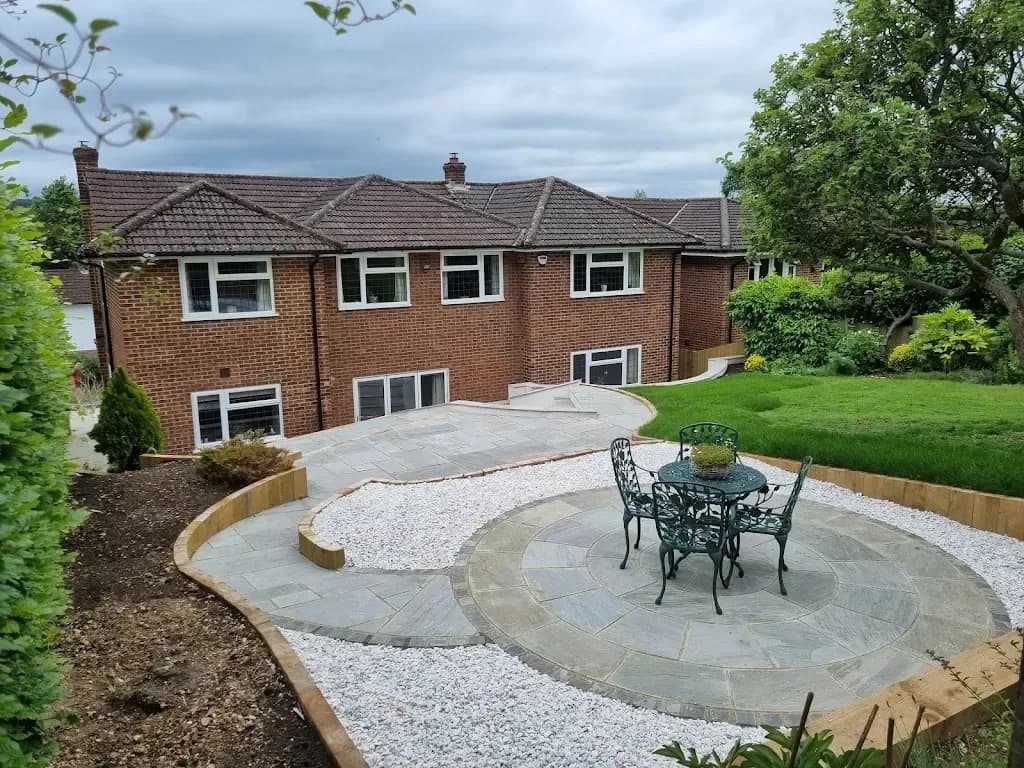 Circular sandstone patio set in white gravel with a bistro table
