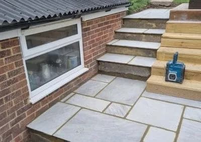 Sandstone steps and paving beside a timber deck
