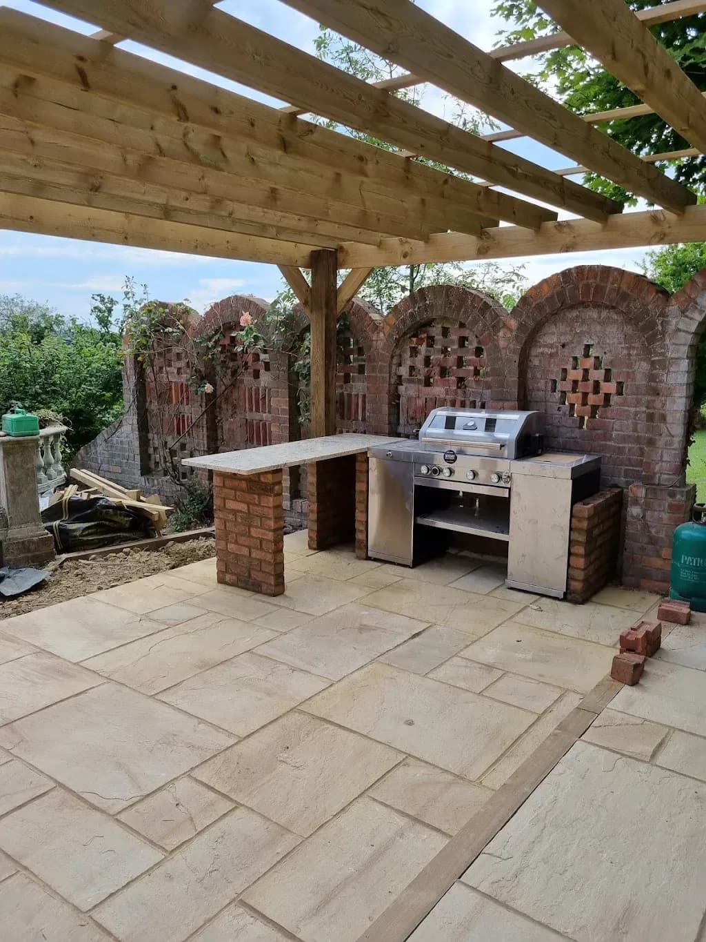 Timber pergola over a sandstone patio with a built in outdoor kitchen